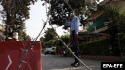 A Pakistani security official stands guard outside a residential area of Islamabad sealed off as part of the new smart lockdown after increasing numbers of coronavirus infections were reported.