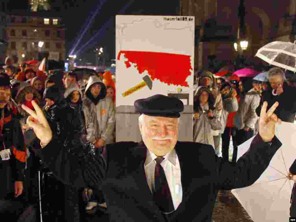 Walesa în faţa unei piese-domino simbolice, bucată din zidul de la Berlin, la aniversarea a 10-a de la căderea zidului, în capitala germană, 9 noiembrie 2009.