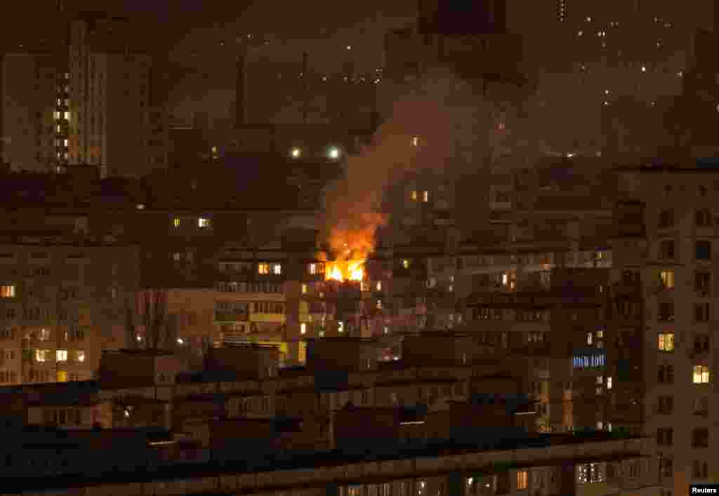 An apartment burns on the top floor of a building in Kyiv after a wave of Russian strikes on March 23. Ukrainian authorities say over the weekend of March 22-23 three people were killed by strikes on Kyiv, including a 5-year-old girl and her father. The latest talks between Russian and American envoys began in Riyadh, Saudi Arabia, on March 24.
