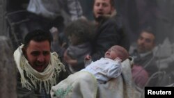 Выжившего ребёнка выносят из разрушенного при авиаударе дома в предместьях Дамаска, 7 января 2014 г.