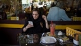 An Iranian woman uses her mobile phone in a coffee shop in Tehran. (file photo)
