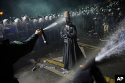 2025-nji ýylyň 23-nji martynda Stambulda geçirilen demonstrasiýa wagtynda gozgalaň polisiýasy bir protestçini yza çekdirmek üçin göz ýaşardyjy serişdesini ulandy.