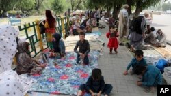 Afghan people rest on tents and blankets as they seek to receive asylum from the United Nations High Commissioner for Refugees in Islamabad on May 9, 2022. 