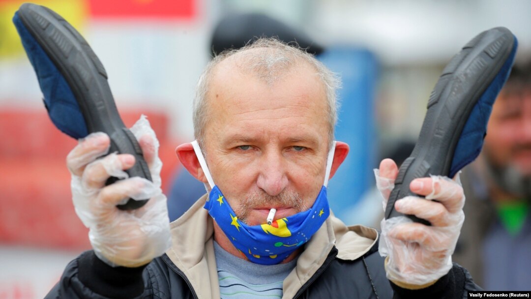Pristalica opozicije u Minsku drži par papuča tokom mitinga 31. maja u svrhu podrške slobodnim predsjedničkim izborima u avgustu.