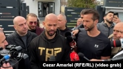 Andrew Tate (left) and his brother, Tristan (right), talk to reporters in front of a Romanian police station on March 24.