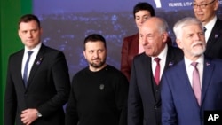 Presidenti ukrainas, Volodymyr Zelensky, në qendër, shikon drejt presidentit hungarez, Tamas Sulyok, djathtas, gjatë një fotoje në grup në një samit në Lituani në prill 2024.