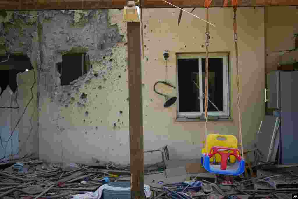 A children's swing hangs in a house damaged by Hamas militants at the Kibbutz Be'eri, Israel, days after the attack.