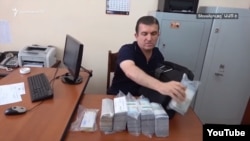 Armenia - Vachagan Ghazarian empties his bag filled with cash after being arrested by the National Security Service in Yerevan, 25 June 2018.